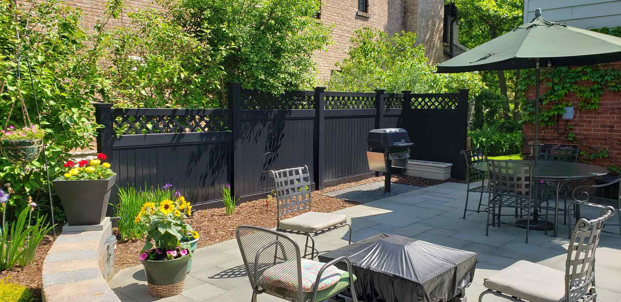 Semi privacy lattice top black vinyl fence along backyard in residential property