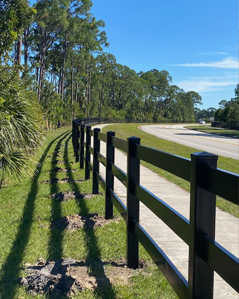 3-rail black vinyl fence along sidewalk