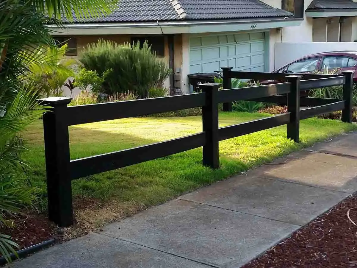 2 rail black vinyl horse or ranch fence installed around the front of a home