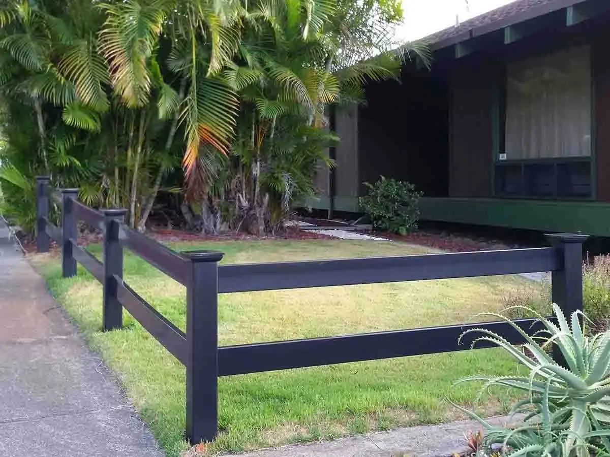 Black vinyl 2 rail fence installed around the front of a home