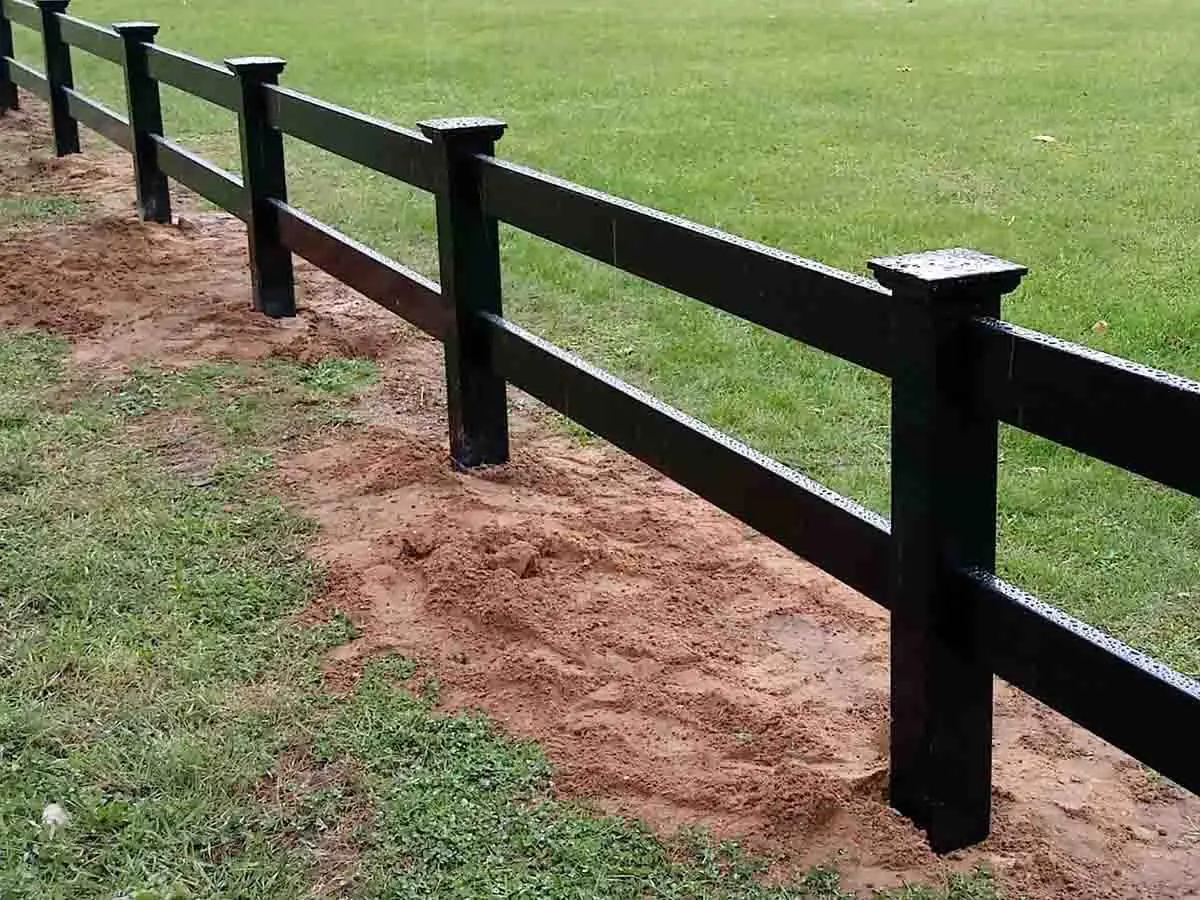 Black vinyl 2 rail ranch fence installed on a pasture