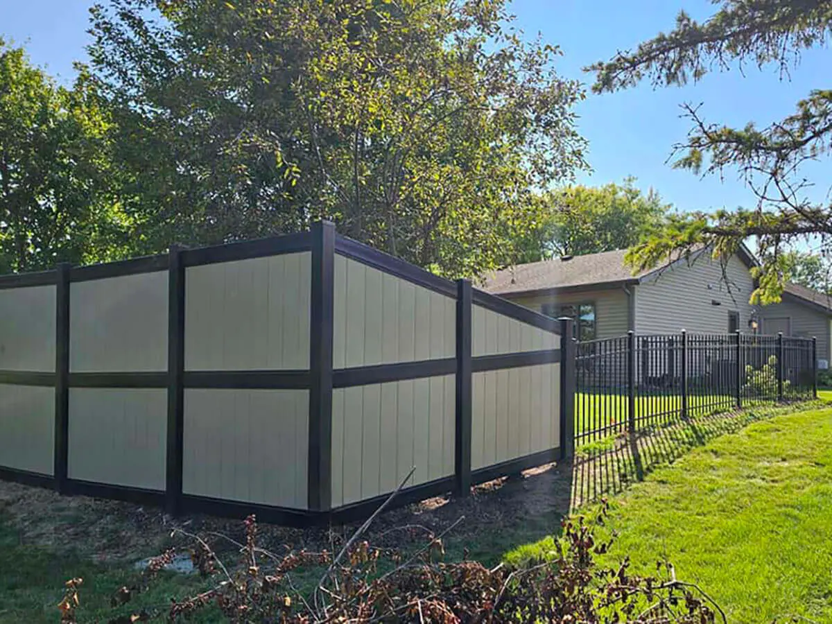 8 ft high vinyl privacy fence with tan infill and black posts and rails