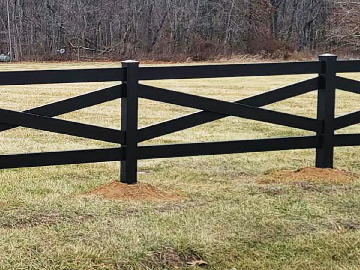 Crossbuck vinyl ranch fence installed around a grassy pasture