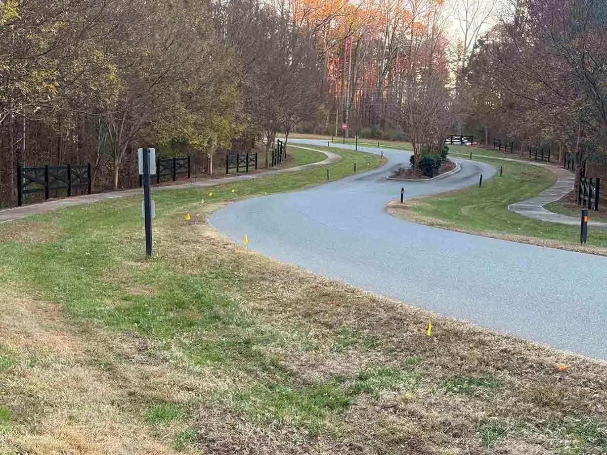 Black vinyl crossbuck style fence installed along a road