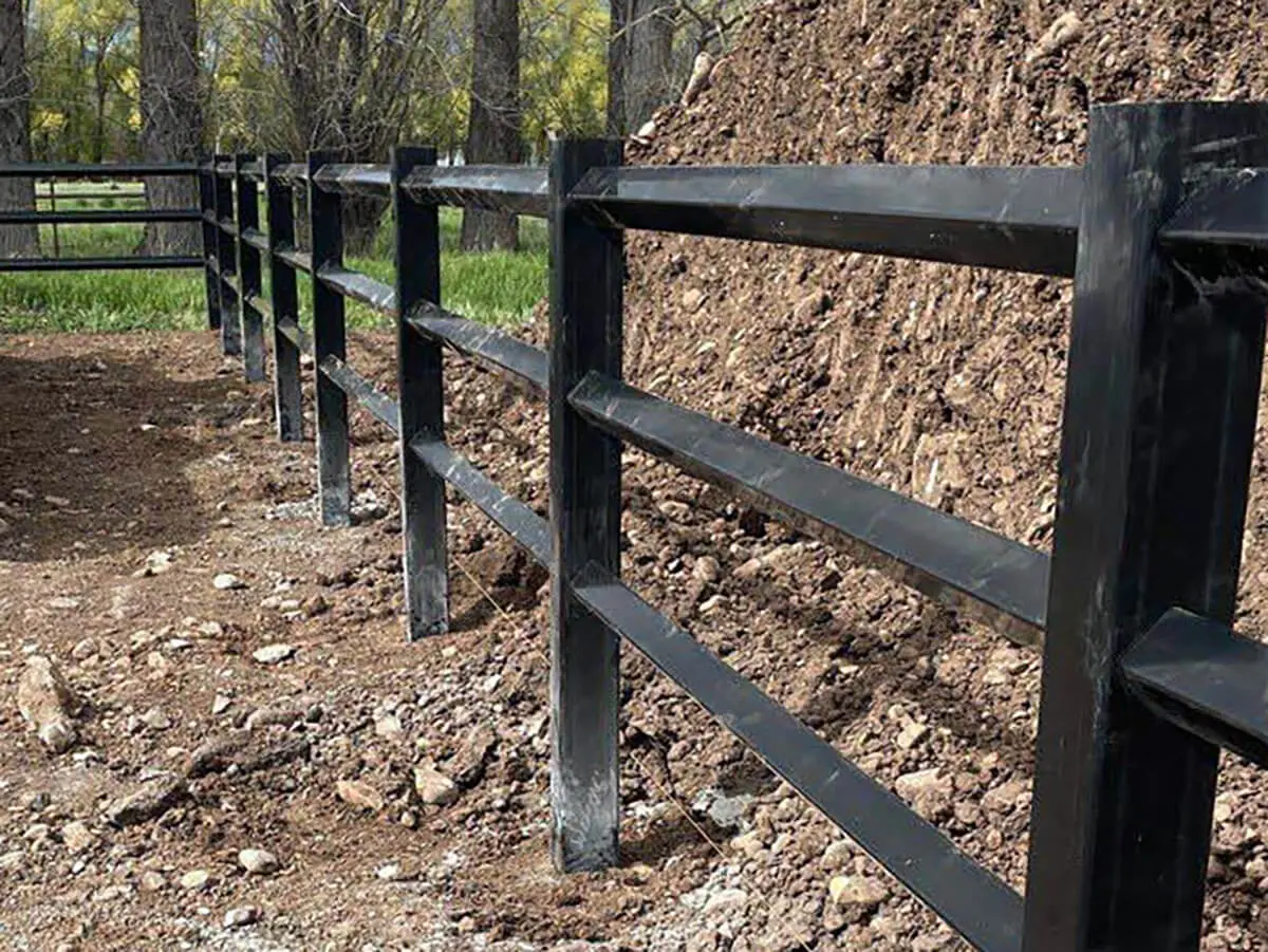 Black vinyl diamond rail fence with 3 rails installed around a pasture