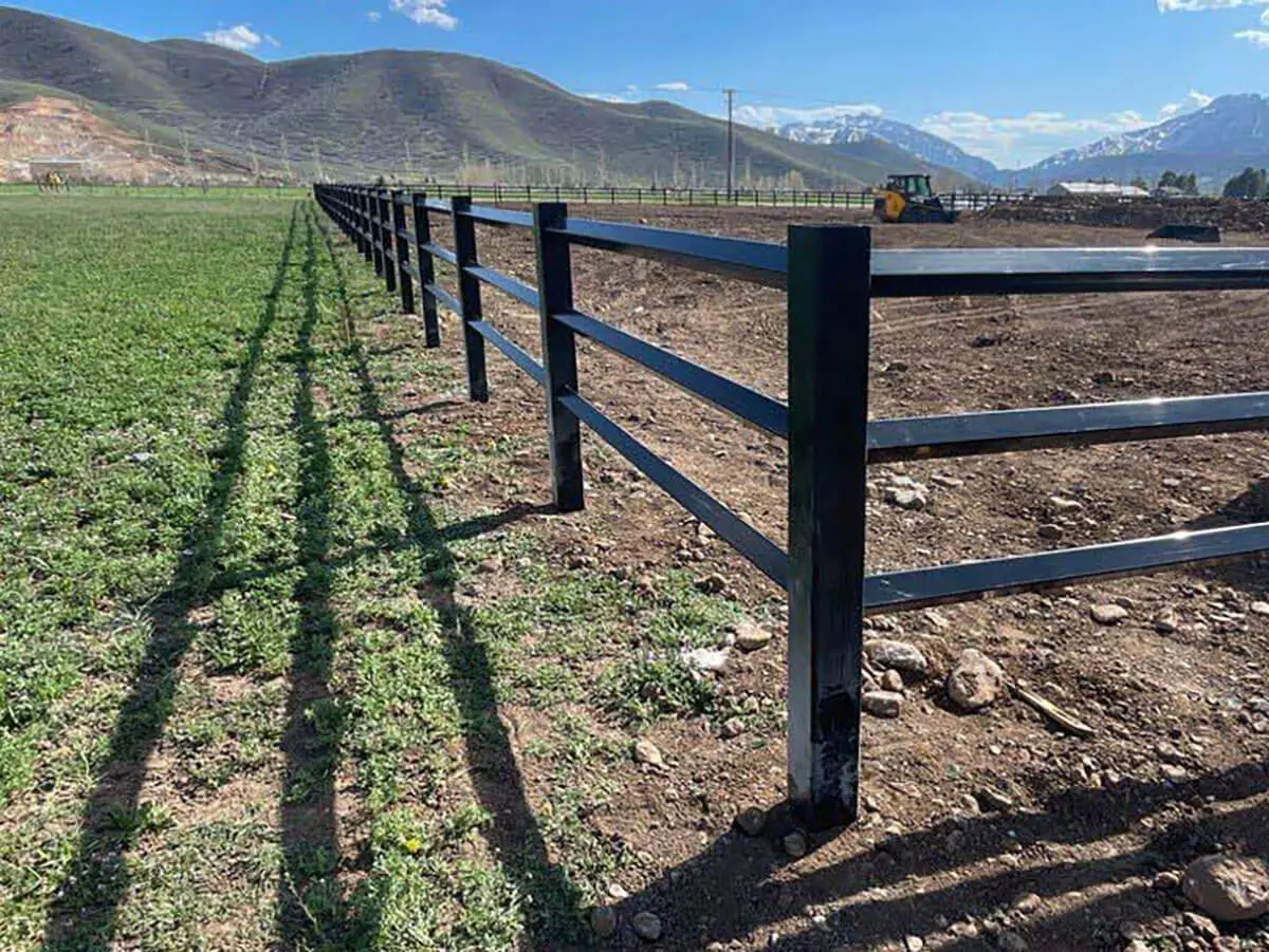 Black vinyl diamond ranch rail installed around a farm pasture