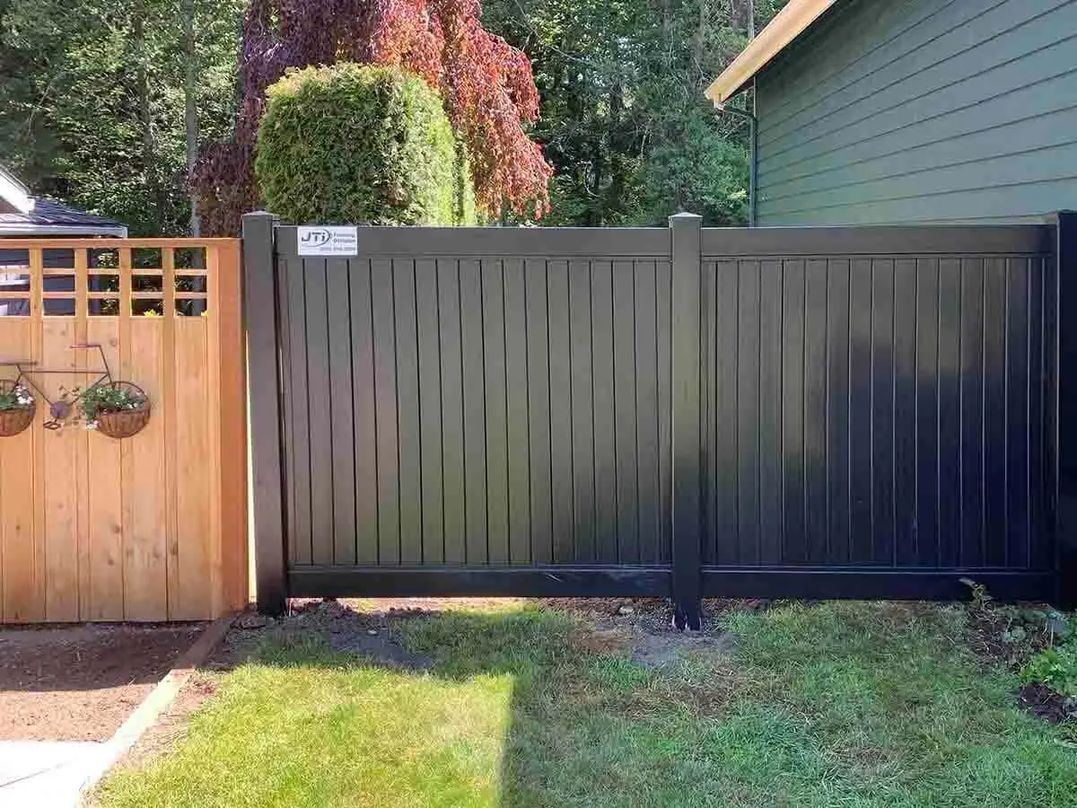 Black vinyl full privacy fence installed around a residential home