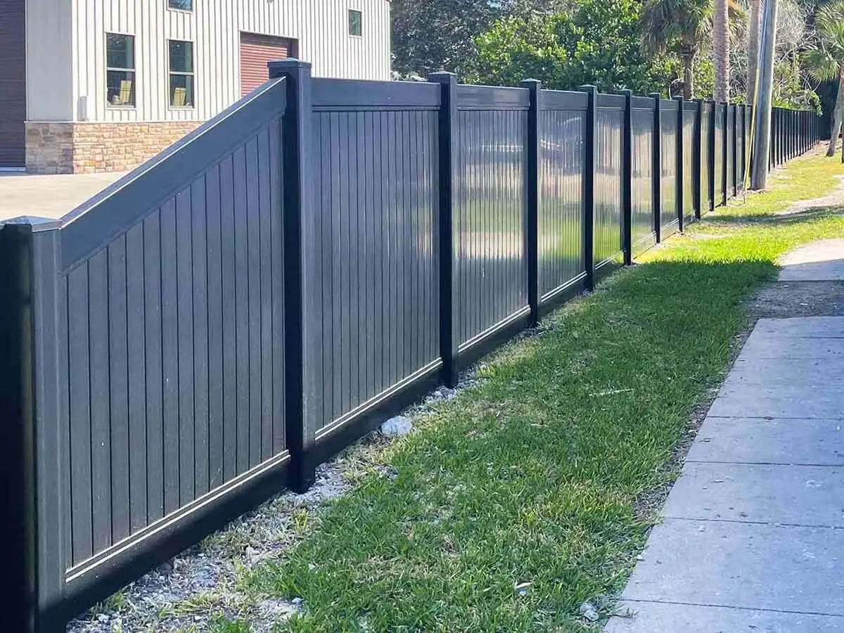 Black full privacy vinyl fence installed around a property line