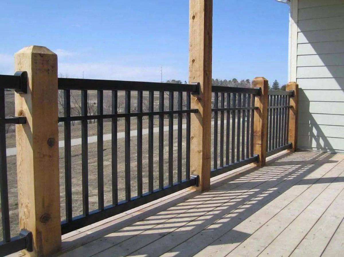 3 rail black vinyl railings in between wood posts installed on a patio